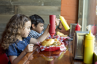 Young boy and girl eating fast food