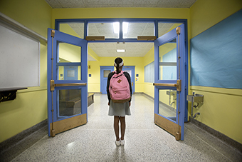 Girl standing in hallway alone at school