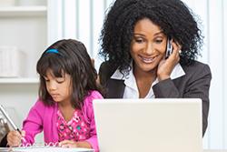 Mom on the phone at her computer with her daughter