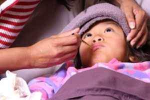 Mom taking daughter's temperature