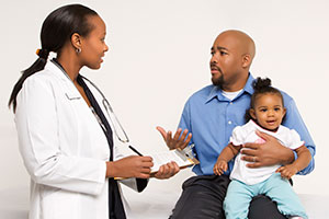 Dad talking to doctor with toddler