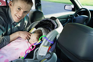 Father securing infant's car seat