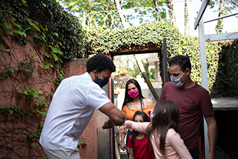 family wearing masks and bumping elbows