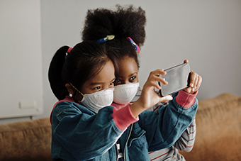 Young girls in masks taking a selfie